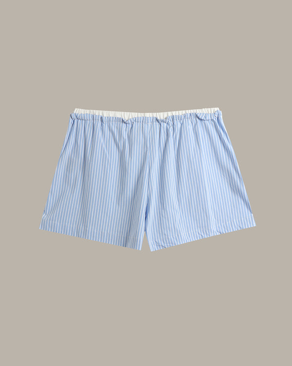Light blue and white vertically striped boxer shorts with an elastic waistband, shown flat against a solid taupe background.