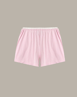 Light pink and white vertically striped boxer shorts with an elastic waistband, shown flat against a solid taupe background.