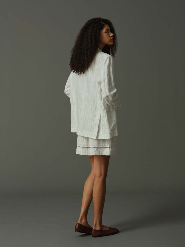 Woman wearing a white outfit against a gray background