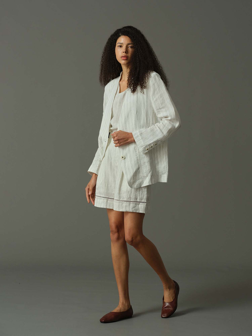 Woman wearing a white outfit on a gray background