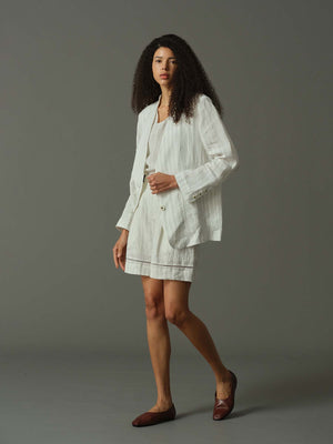 Woman wearing a white outfit on a gray background