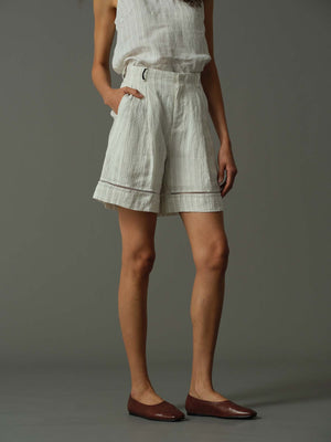 Person wearing light-colored shorts with a subtle pattern on a gray background