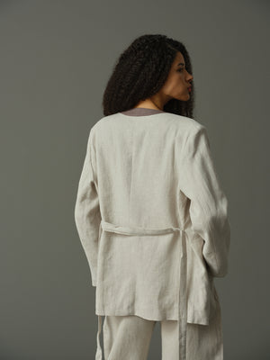 Woman wearing a light grey outfit against a plain background