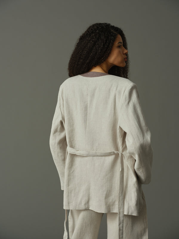 Woman wearing a light grey outfit against a plain background