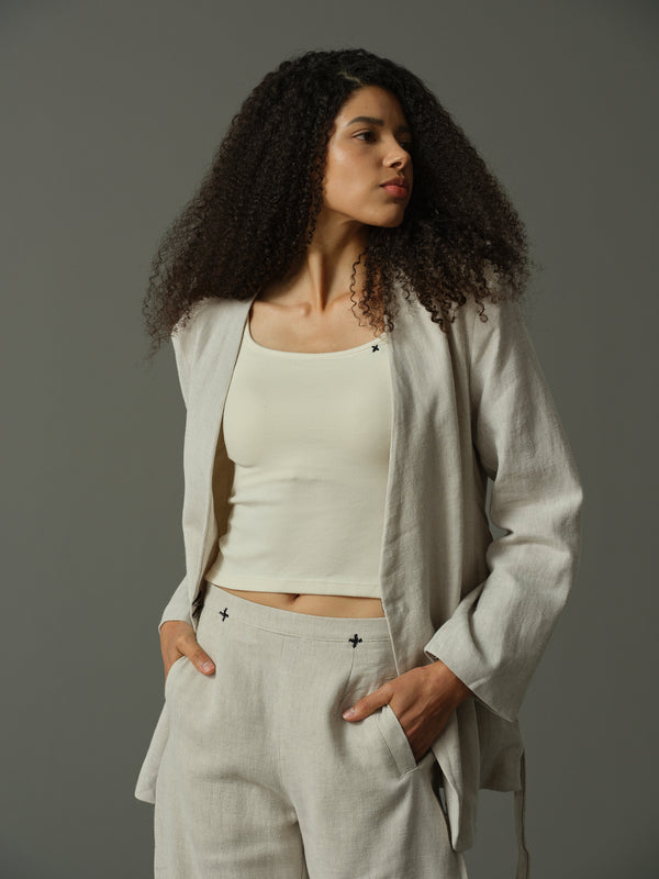 Woman wearing a light gray outfit with a plain background