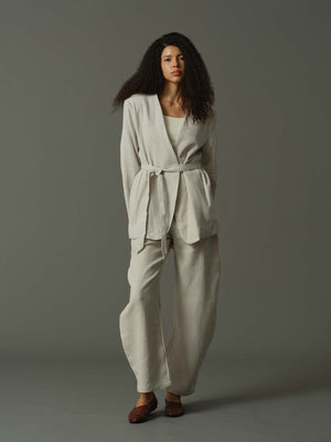 Woman wearing a light gray outfit against a gray background