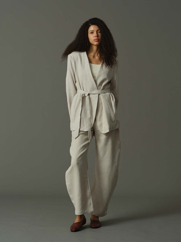 Woman wearing a light gray outfit against a gray background