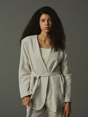 Woman wearing a light gray Tie-Waist Collarless Blazer against a plain background