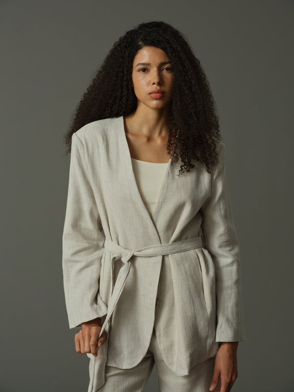 Woman wearing a light gray Tie-Waist Collarless Blazer against a plain background