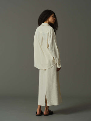 Woman wearing a white outfit on a gray background