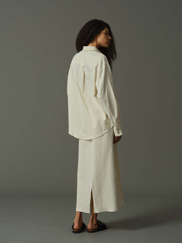 Woman wearing a white outfit on a gray background