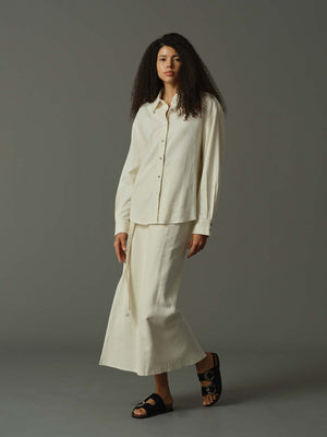 Woman wearing a white outfit against a gray background