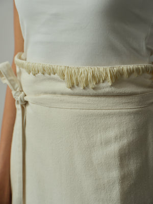 Close-up of a white apron with frayed edges on a neutral background