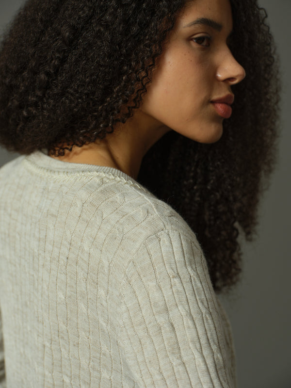 Woman wearing a textured sweater against a neutral background