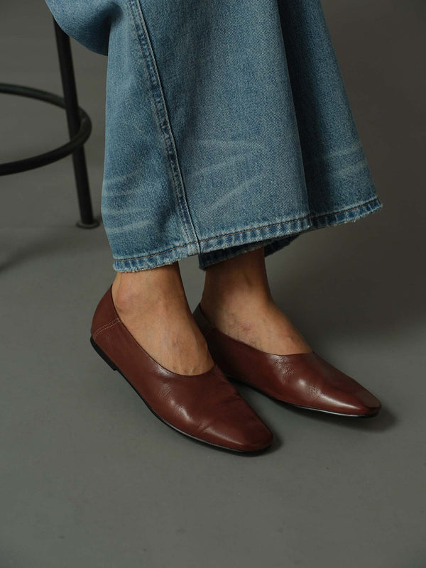 close up of model wearing a pair of brown leather flats