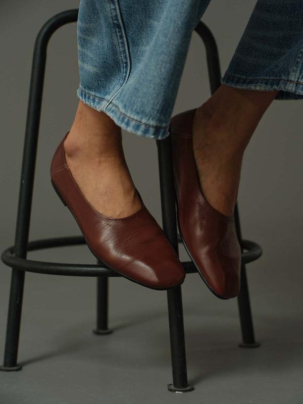 close up of model wearing a pair of brown leather flats