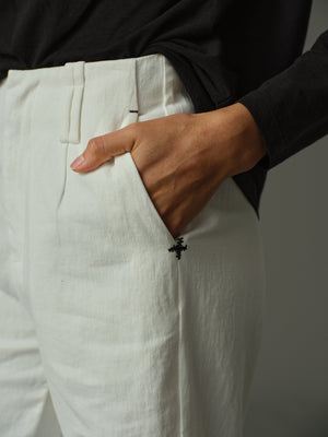 Person wearing white pants with a black background