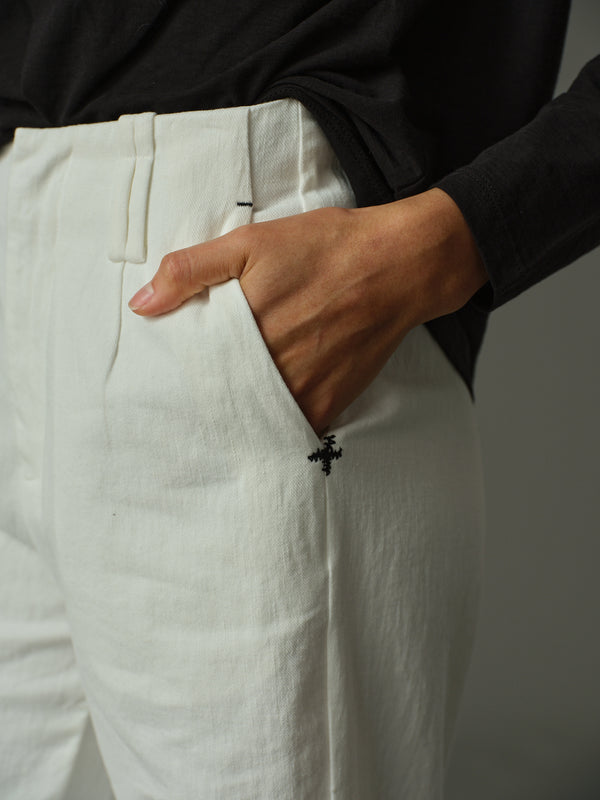 Person wearing white pants with a black background