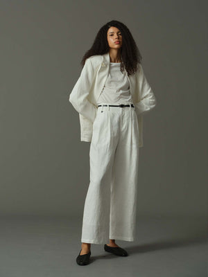 Woman wearing a white outfit against a gray background