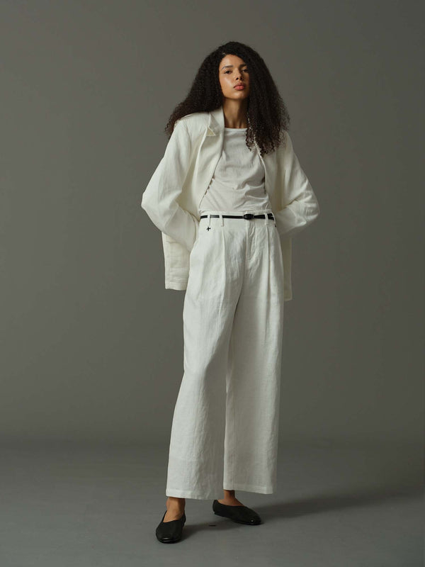 Woman wearing a white outfit against a gray background