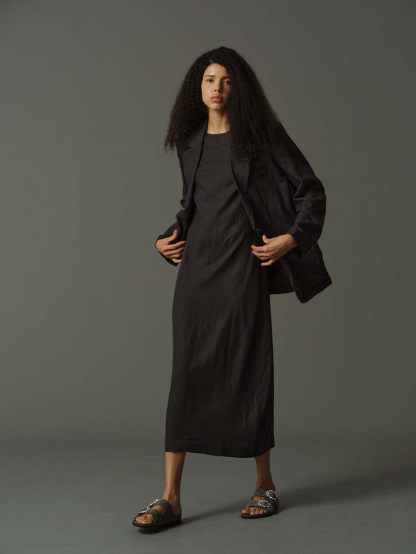 Woman wearing a black outfit against a gray background