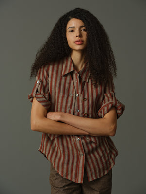 Woman wearing a striped shirt against a gray background