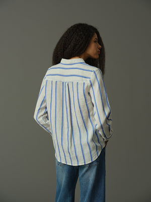 Person wearing a blue and white striped shirt against a gray background