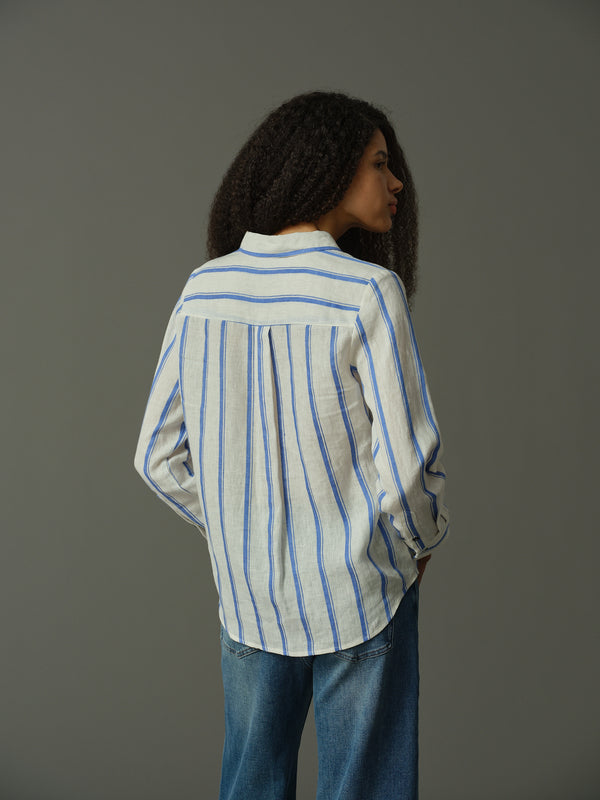 Person wearing a blue and white striped shirt against a gray background