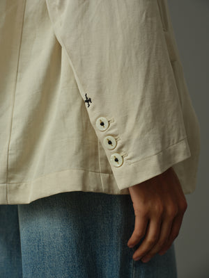 Close-up of a beige jacket with buttons and a blurred background