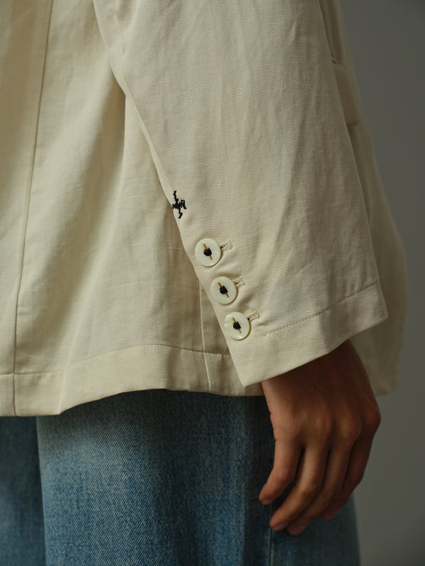 Close-up of a beige jacket with buttons and a blurred background