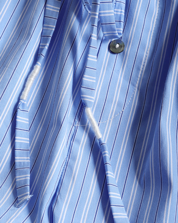 Close-up of a blue and white striped dress shirt fabric, showing the collar, button, and a loose white thread near the placket.