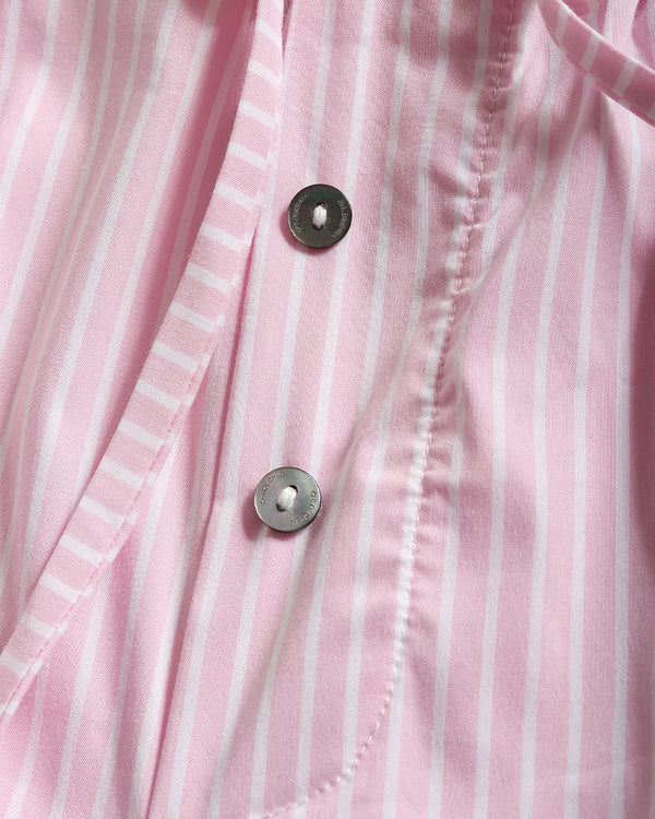 Close-up of a pink and white vertically striped button-up shirt showing the fabric texture and two dark metal buttons.