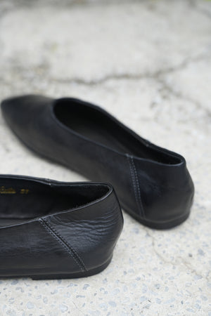 Pair of black leather shoes on a textured surface