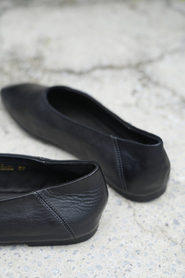 Pair of black leather shoes on a textured surface