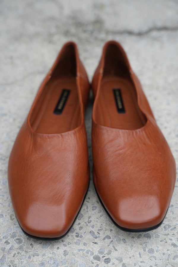 Pair of brown leather shoes on a textured surface