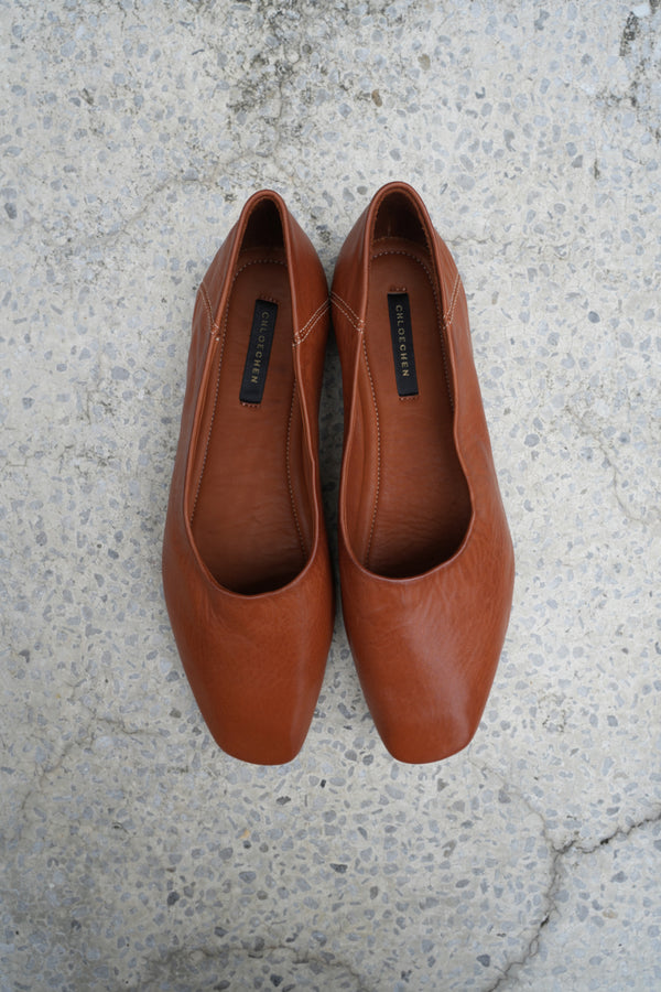 Pair of brown leather shoes on a textured concrete surface