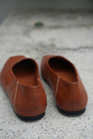 Pair of brown leather shoes on a textured surface
