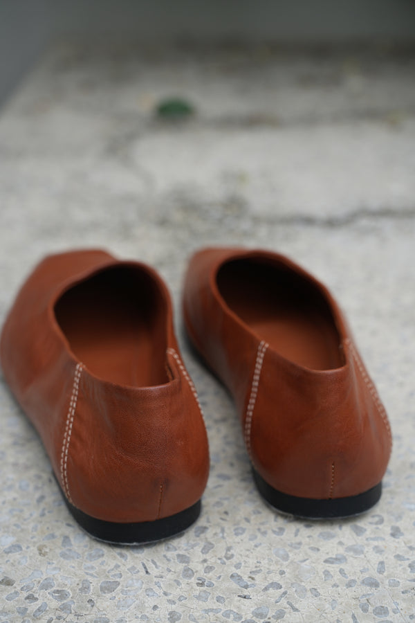 Pair of brown leather shoes on a textured surface