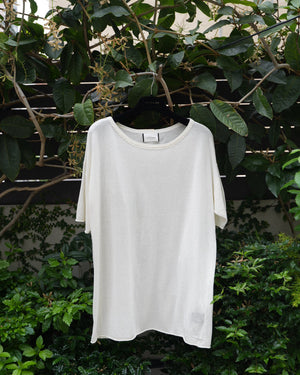a white top hanging on the tree