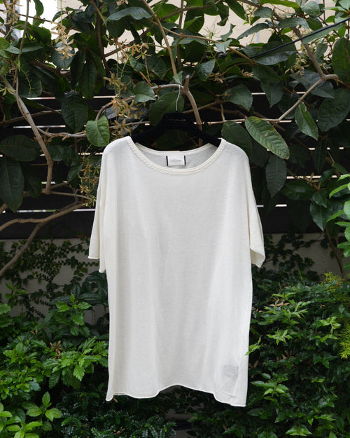 a white top hanging on the tree