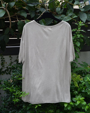 back of a grey top hanging on the tree 
