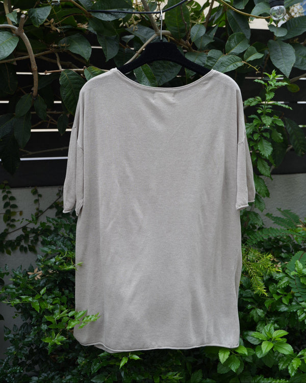 back of a grey top hanging on the tree 