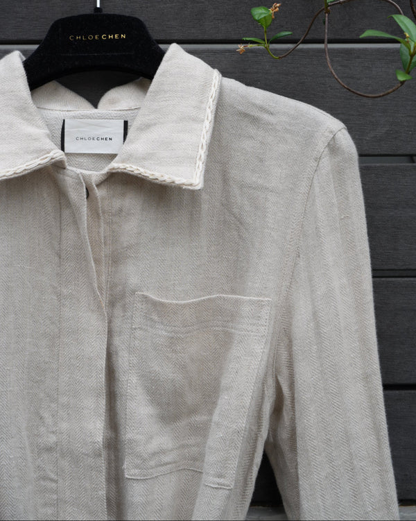 close up of a linen jacket with a brand label on a dark surface