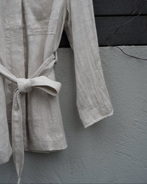 close up of a jacket's waist and sleeves on a gray surface