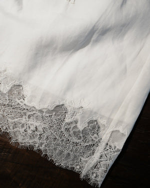 Close-up of a white lace garment on a dark surface