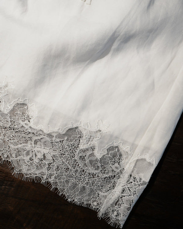 Close-up of a white lace garment on a dark surface