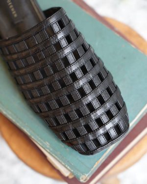 Black woven object on a textured surface
