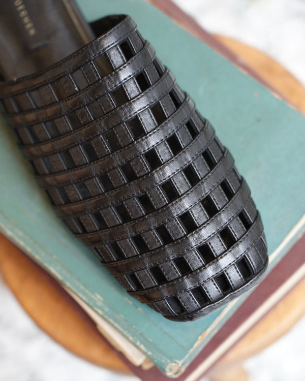Black woven object on a textured surface