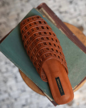 Brown woven sandal on a book with a blurred background