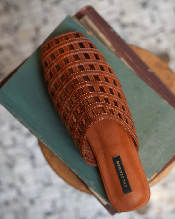 Brown woven sandal on a book with a blurred background